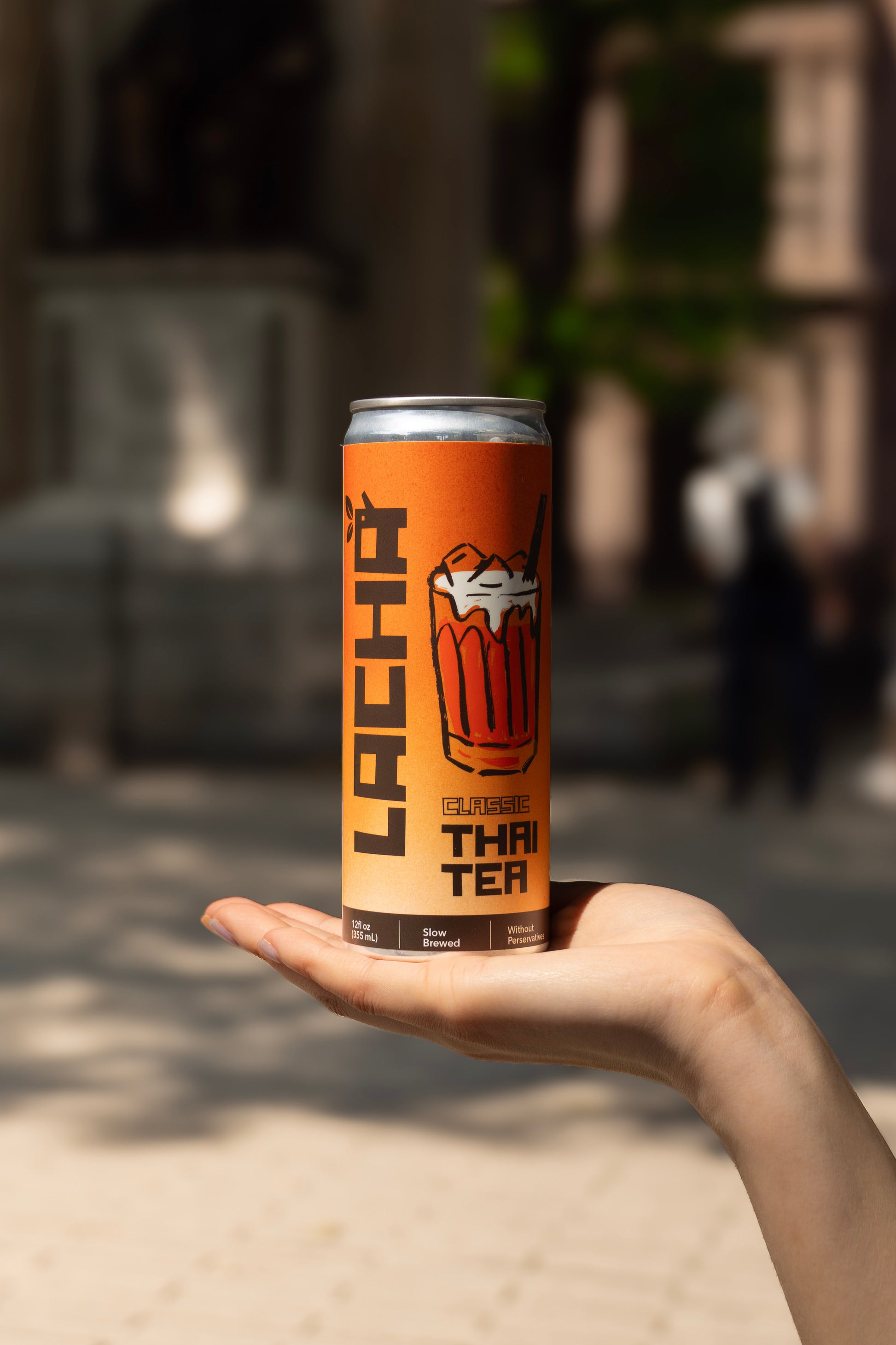 Handing propping up lacha thai iced tea can